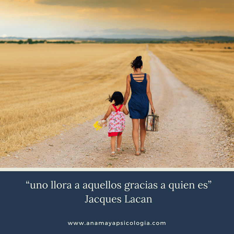 Una mujer y una joven tomadas de la mano caminan por un camino de tierra a través de un campo al atardecer, encarnando la esencia del doloroso duelo. La imagen incluye una cita en español de Jacques Lacan, "uno llora a aquellos gracias a quien es.