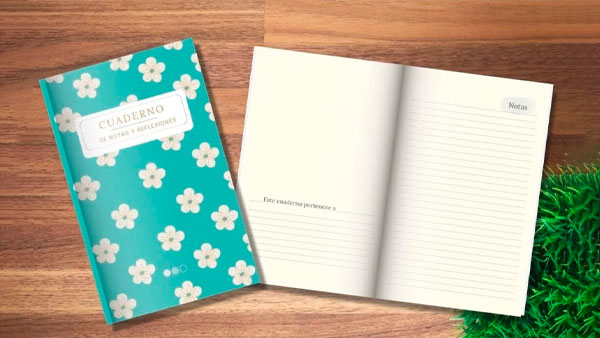 Un cuaderno verde azulado con flores blancas en la portada se muestra junto a una página abierta y rayada. La página tiene el título "Notas" en la parte superior. El cuaderno y la página están sobre una superficie de madera con una planta verde, lo que lo hace perfecto para cualquiera que ame los libros y las publicaciones hermosas.
